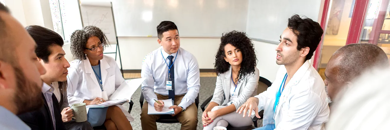 Diverse group of professionals in a circle discussing workplace practice